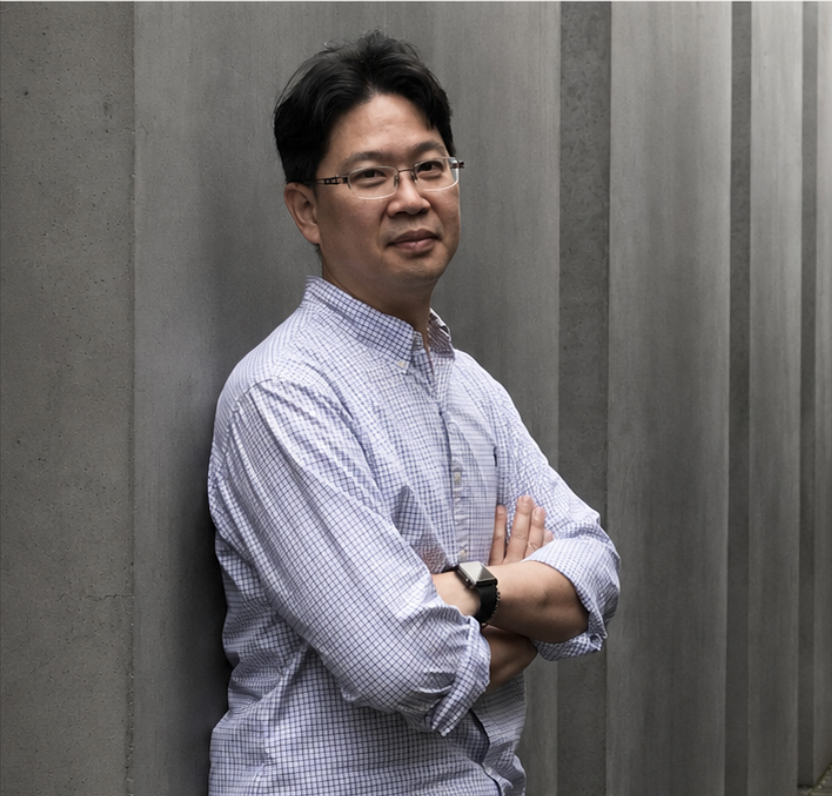Po-Wei Weng standing against a concrete wall